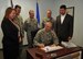 Master Sgt. Martin Vessels, 9th Contracting Squadron construction flight chief, signs a contract regarding upcoming renovations to the pool in base housing