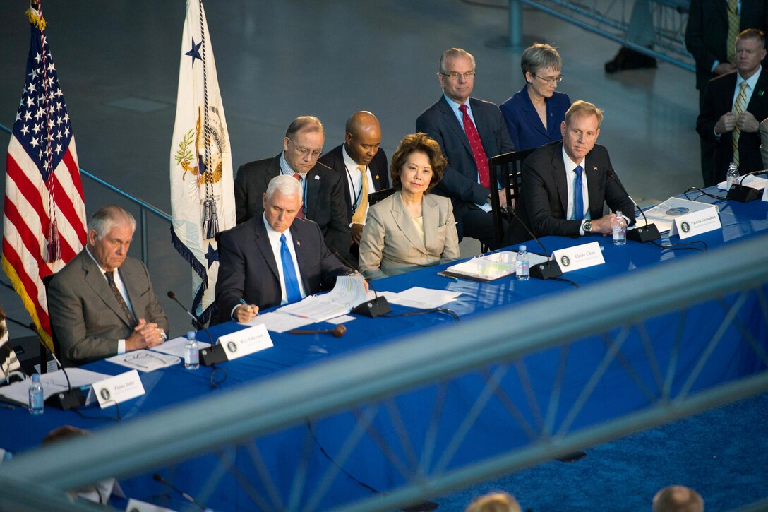 A group of people sit behind a table.