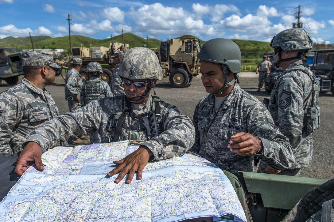 Airmen review a map before a recovery mission.