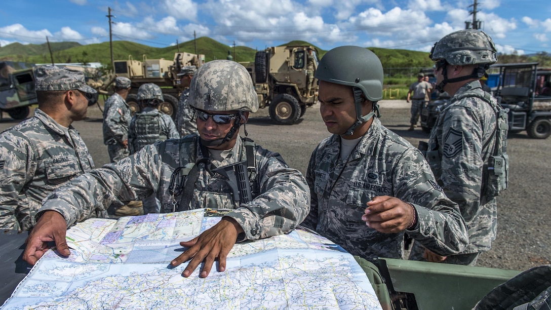 Airmen review a map before a recovery mission.