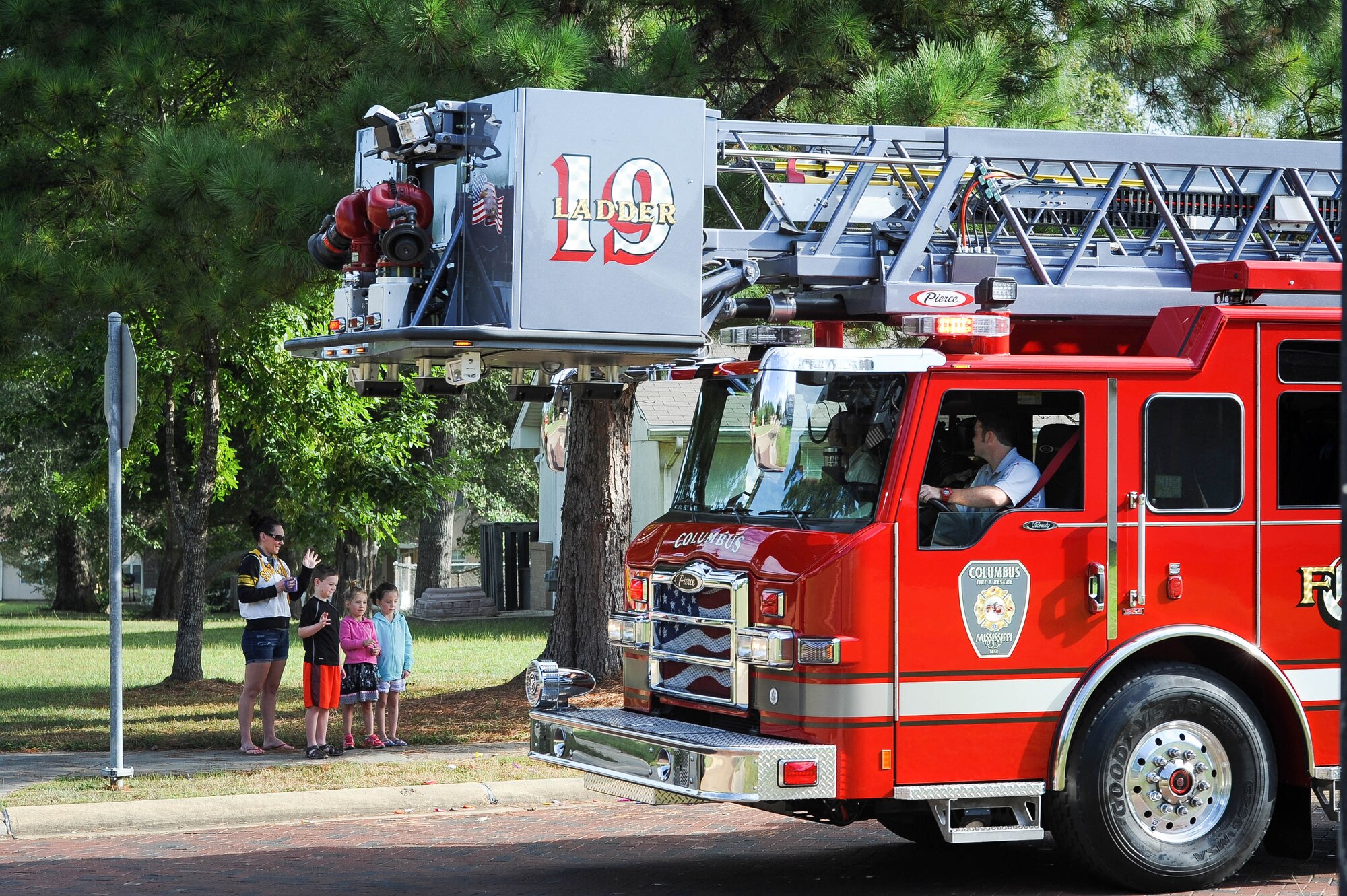 A family in Magnolia Village on Columbus Air Force Base, Mississippi, waves to a fire truck from the City of Columbus Fire and Rescue Sept. 30, 2017, as part of a parade for Fire Prevention Week. Members of the Columbus AFB Fire Department planned a week full of fire prevention events from Sept. 25-30, and this year’s theme was “Every Second Counts: Plan 2 Ways Out!” (U.S. Air Force photo by Staff Sgt. Christopher Gross)