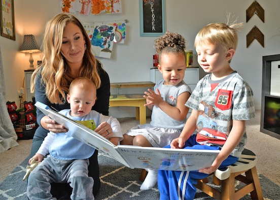 Family Child Care provider Emily Horn reads to (left to right) Alden Von Thaden, Kendall Finley and Benjamin Brown Oct. 5 during playtime at her on-base, FCC home.