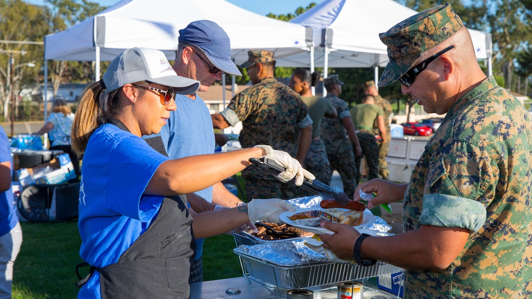 Local volunteers serve Headquarters and Support Battalion Marines, Sailors and their families food during the Spiritual Fitness Fair at Camp Pendleton’s Paige Fieldhouse, Oct. 5, 2017. The Spiritual Fitness Fair was organized to promote spiritual and mental wellness with the end state being a safe, well attended event that enhances the morale and esprit de corps of the battalion. (Official Marine Corps photo by Lance Cpl. Anabel Abreu Rodriguez)