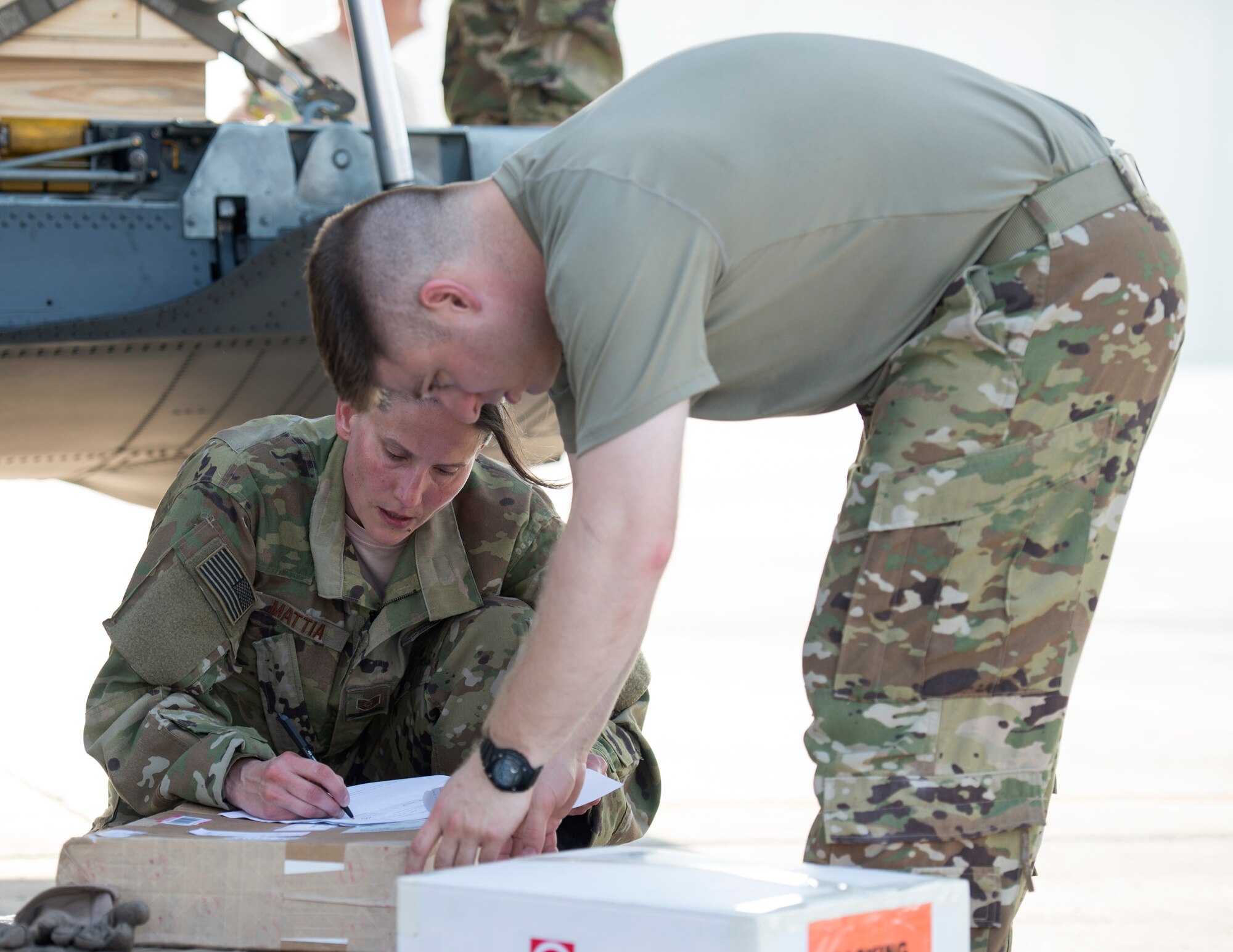 U.S. Air Force Tech. Sgts. Amy Mattia and Ronald Toia, loadmasters with the 746th Expeditionary Airlift Squadron, sign for mail and review squadron paperwork at Al Udeid Air Base, Qatar, Oct. 3, 2017.