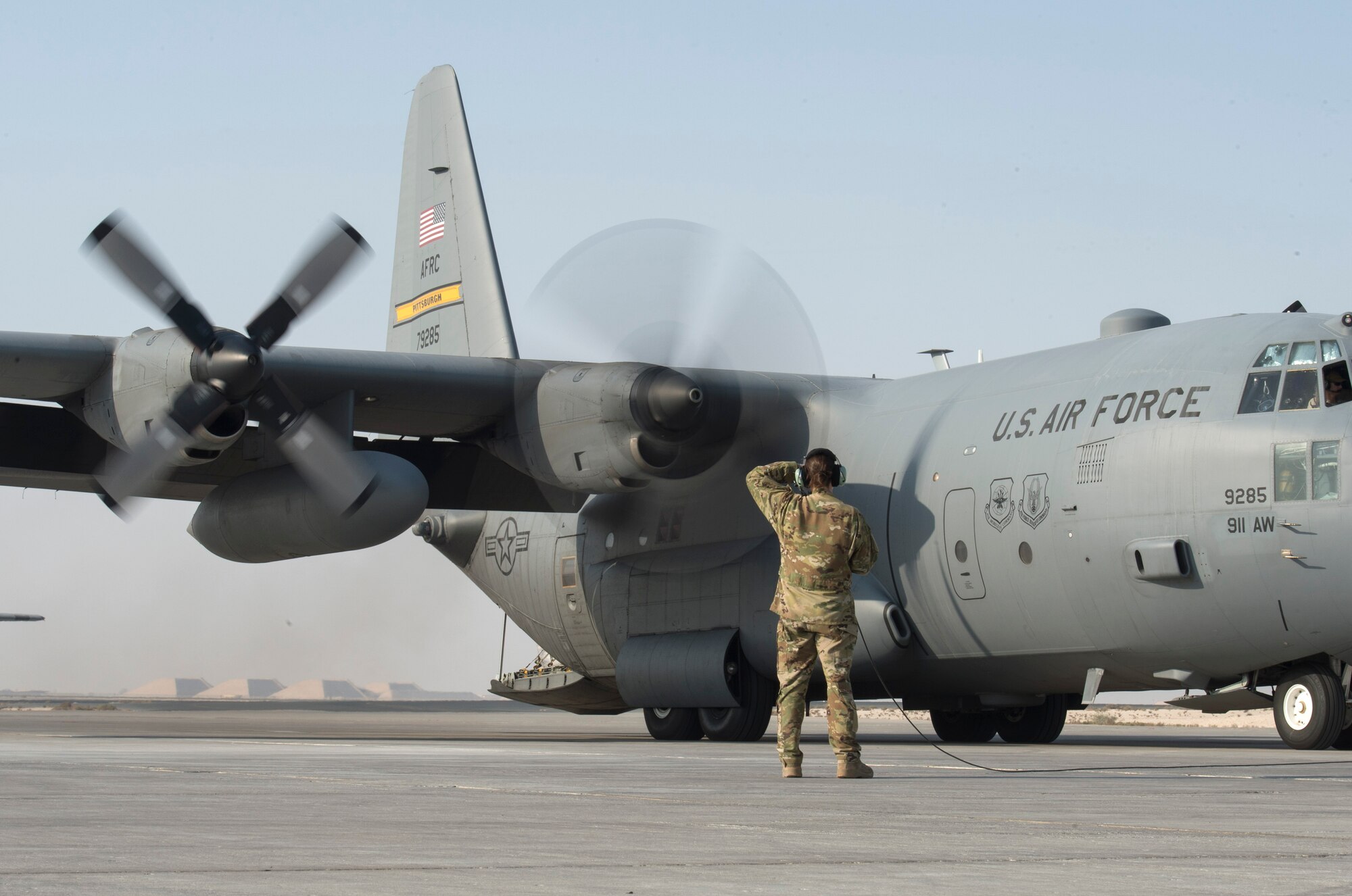 U.S. Air Force Tech. Sgt. Amy Mattia, loadmaster with the 746th Expeditionary Airlift Squadron, watches a C-130 Hercules turbo prop engine start up at Al Udeid Air Base, Qatar, Oct. 3, 2017.