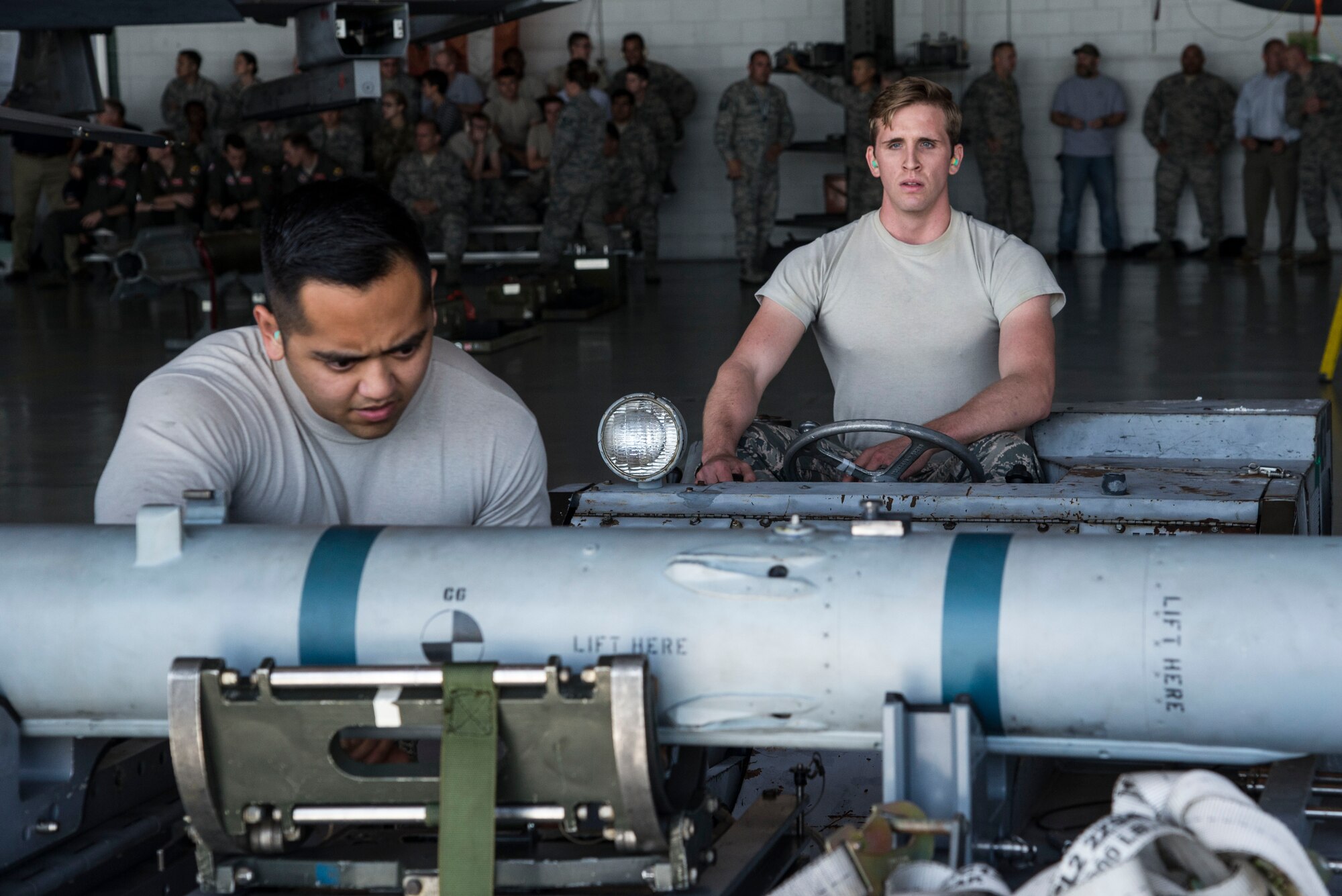 U.S. Air Force Staff Sgt. Joaquin Arevalo, 20th Aircraft Maintenance Squadron (AMXS) load crew team chief, left, and Senior Airman Jonathan Paulukaitis, 20th AMXS load crew member, load an AIM-120 advanced medium-range air-to-air missile onto a bomb-loader during a quarterly load crew competition at Shaw Air Force Base, S.C., Oct. 4, 2017.