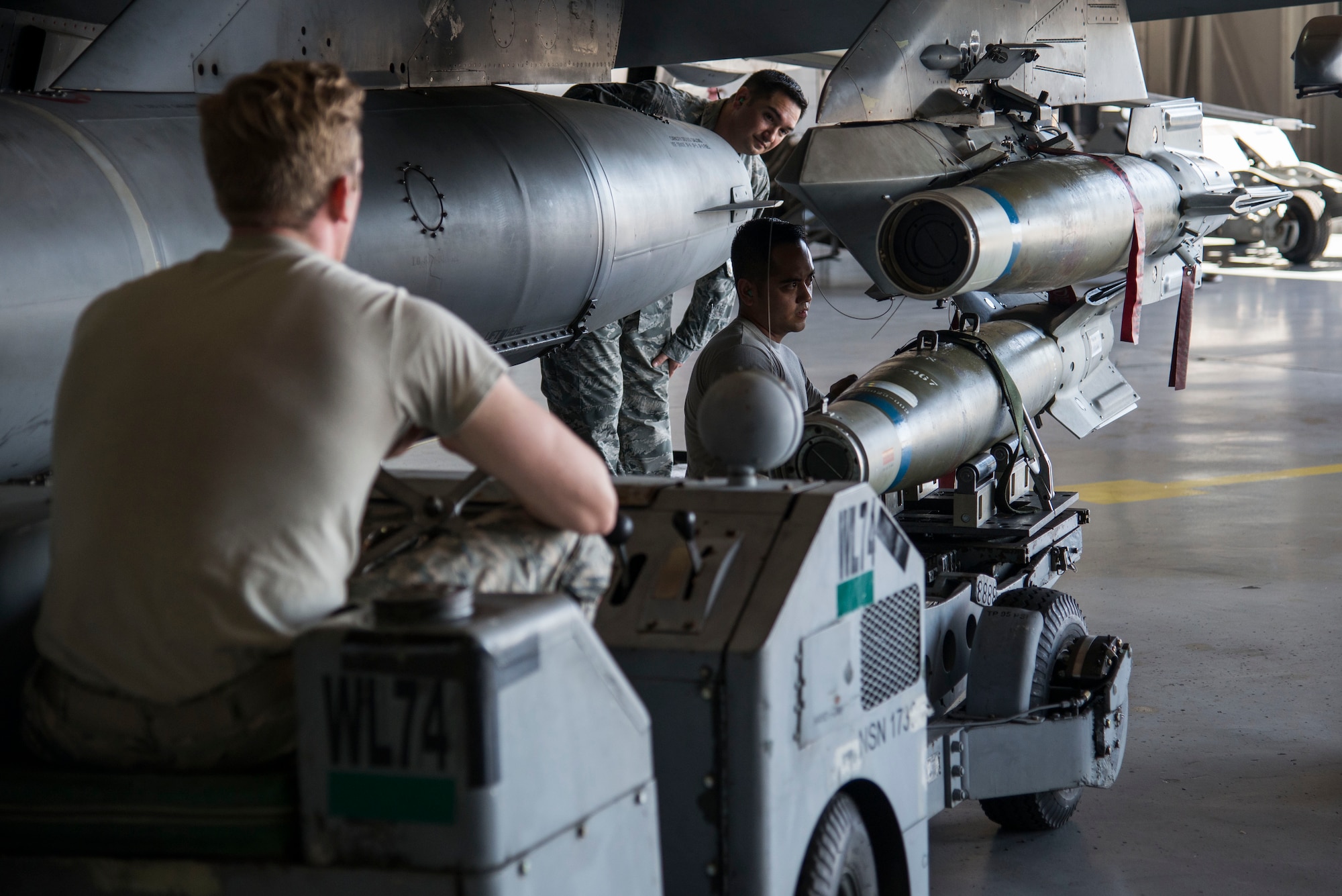 U.S. Air Force Senior Airman Jonathan Paulukaitis, 20th Aircraft Maintenance Squadron (AMXS) load crew member, left, and Staff Sgt. Joaquin Arevalo, 20th AMXS load crew team chief, right, attach a GBU-12 Paveway II laser-guided bomb to the wing of an F-16CM Fighting Falcon, while Staff Sgt. William Bernhardt, 20th AMXS load crew evaluator, observes the process for accuracy during a quarterly load crew competition at Shaw Air Force Base, S.C., Oct. 4, 2017.