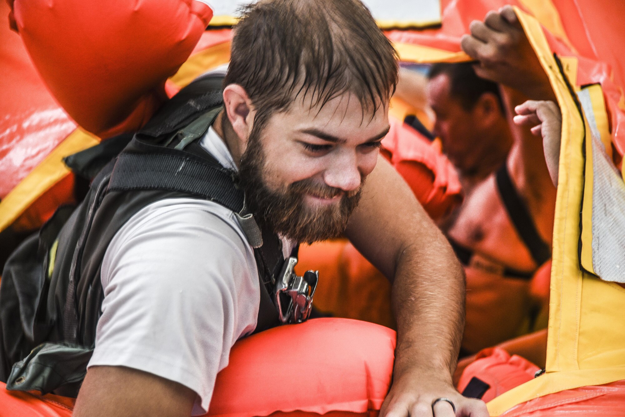 An airman begins to exit a raft after instructors from the 58th Operations Support Squadron explained the importance of keeping calm in high stress situations.  Airmen from the 377th Force Support Squadron and 150th Special Operations Wing completed an overturned-aircraft simulation, compressed-air breathing exercises and various parachute escape exercises.