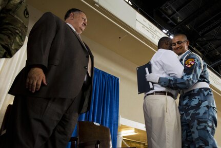 Charles Rose, left, director of the Maryland National Guard’s Freestate ChalleNGe Academy, looks on as Ronny Colindres, right, embraces academy staff members as he accepts his diploma during graduation ceremonies in June 2016 at the Fifth Regiment Armory in Baltimore.