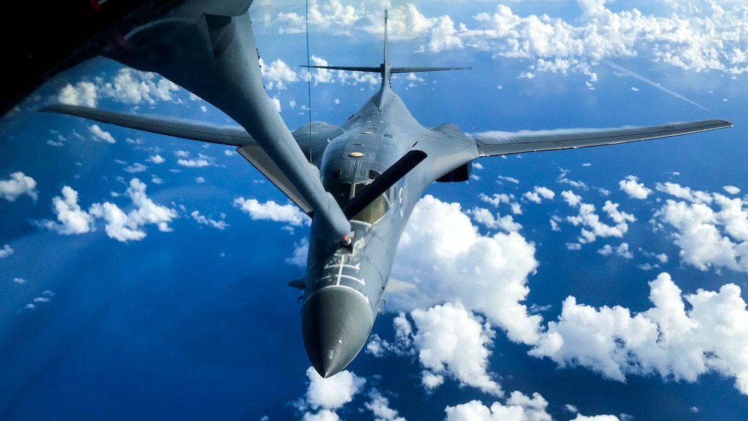 An aircraft receives fuel from the boom of another aircraft while in flight.