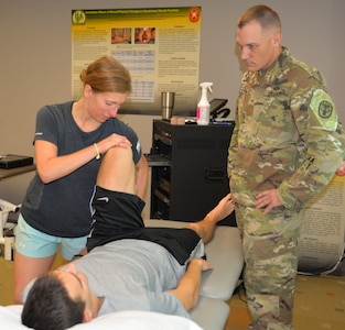 1st Lt. Veronica Lazar (left), Army-Baylor University Doctor of Physical Therapy program intern, practices a physical therapy technique on 1st Lt. Aaron Wilson, Army-Baylor University Doctor of Physical Therapy program intern, while taking instructions from Maj. Justin Zimmerman, student clinician in the Army-Baylor University Doctoral Fellowship in Orthopaedic Manual Physical Therapy program, as part of a research project at the Capt. Jennifer M. Moreno Primary Clinic at Joint Base San Antonio-Fort Sam Houston.