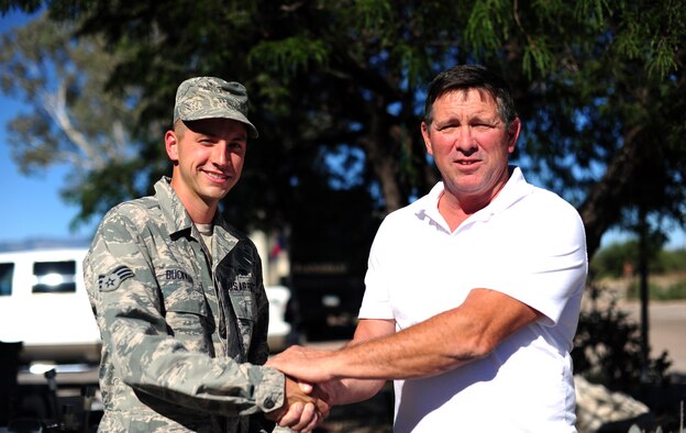 U.S. Air Force Senior Airman Keith Buckman, 923rd Aircraft Maintenance Squadron aerospace propulsion technician, and Mark Byrne, a 57-year-old Army veteran, share a handshake at Davis-Monthan Air Force Base, Ariz., Oct. 2, 2017. Buckman came to Byrne's aid in the middle of the night and helped get him the medical attention he needed during a Transient Ischemic Attack. (U.S. Air Force photo by Airman 1st Class Frankie D. Moore)