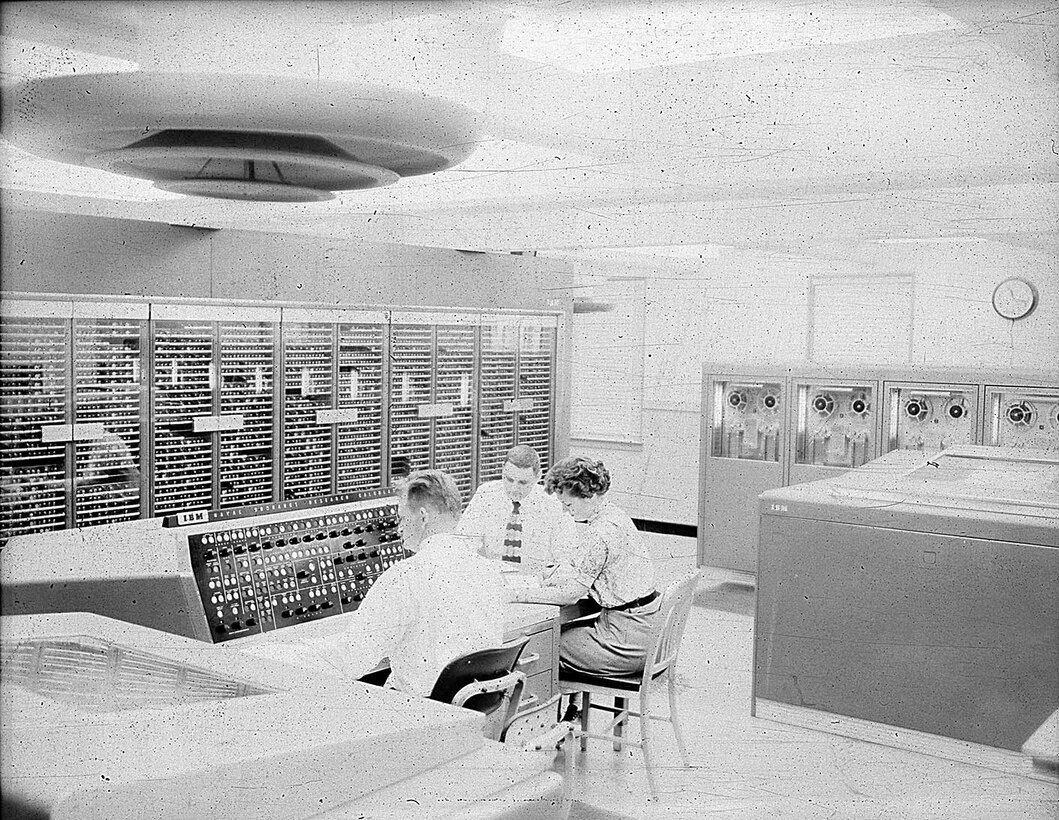 IMAGE: 09/23/1955
This view of the calculator shows an operator at the NORC console where he
can start and stop the calculator and guide its progress on a problem. The printer at his left prints
18,000 characters a minute recording the problems progress." NORC, IBM computer room.( with 3
personnel)