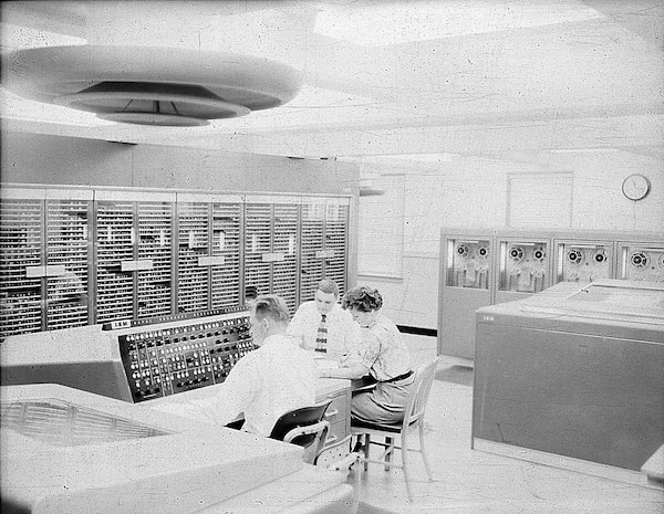 IMAGE: 09/23/1955
This view of the calculator shows an operator at the NORC console where he
can start and stop the calculator and guide its progress on a problem. The printer at his left prints
18,000 characters a minute recording the problems progress." NORC, IBM computer room.( with 3
personnel)