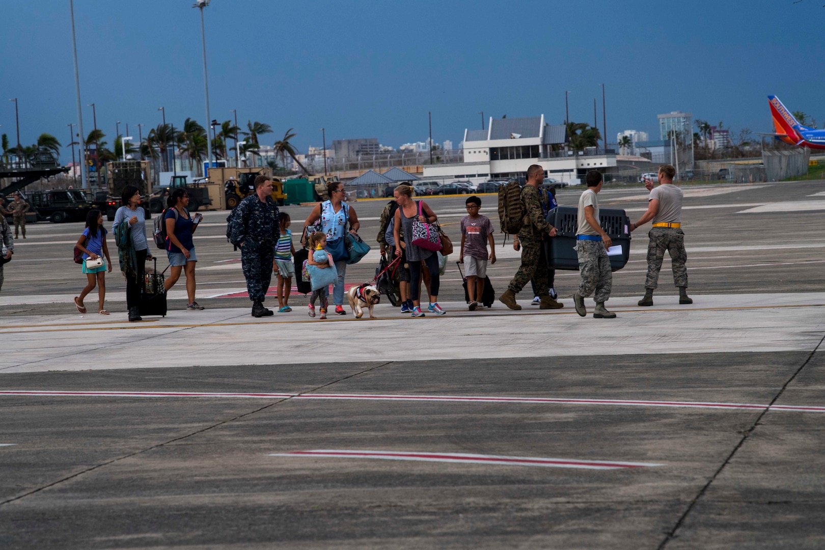 Families prepare to load onto a C-130 Hercules Oct. 5, 2017, to evacuate from San Juan, Puerto Rico.