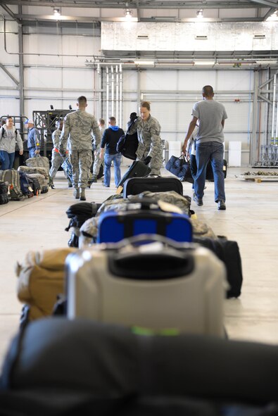 Airmen pick up their luggage after their arrival to Fairford Royal Air Force Base, Sept. 11, 2017.