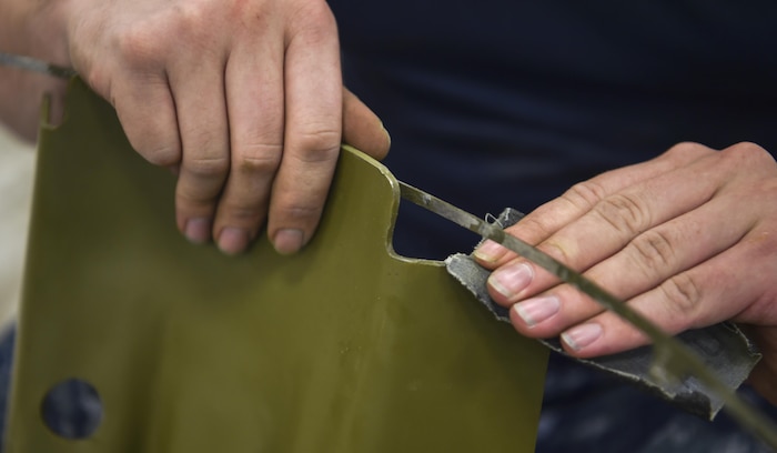 Mineman 3rd Class Alonso Tamez, Navy Munitions Command Atlantic Unit Charleston, buffs a Mark 15 fin at Joint Base Charleston Weapons Station, S.C., Aug. 29, 2017.