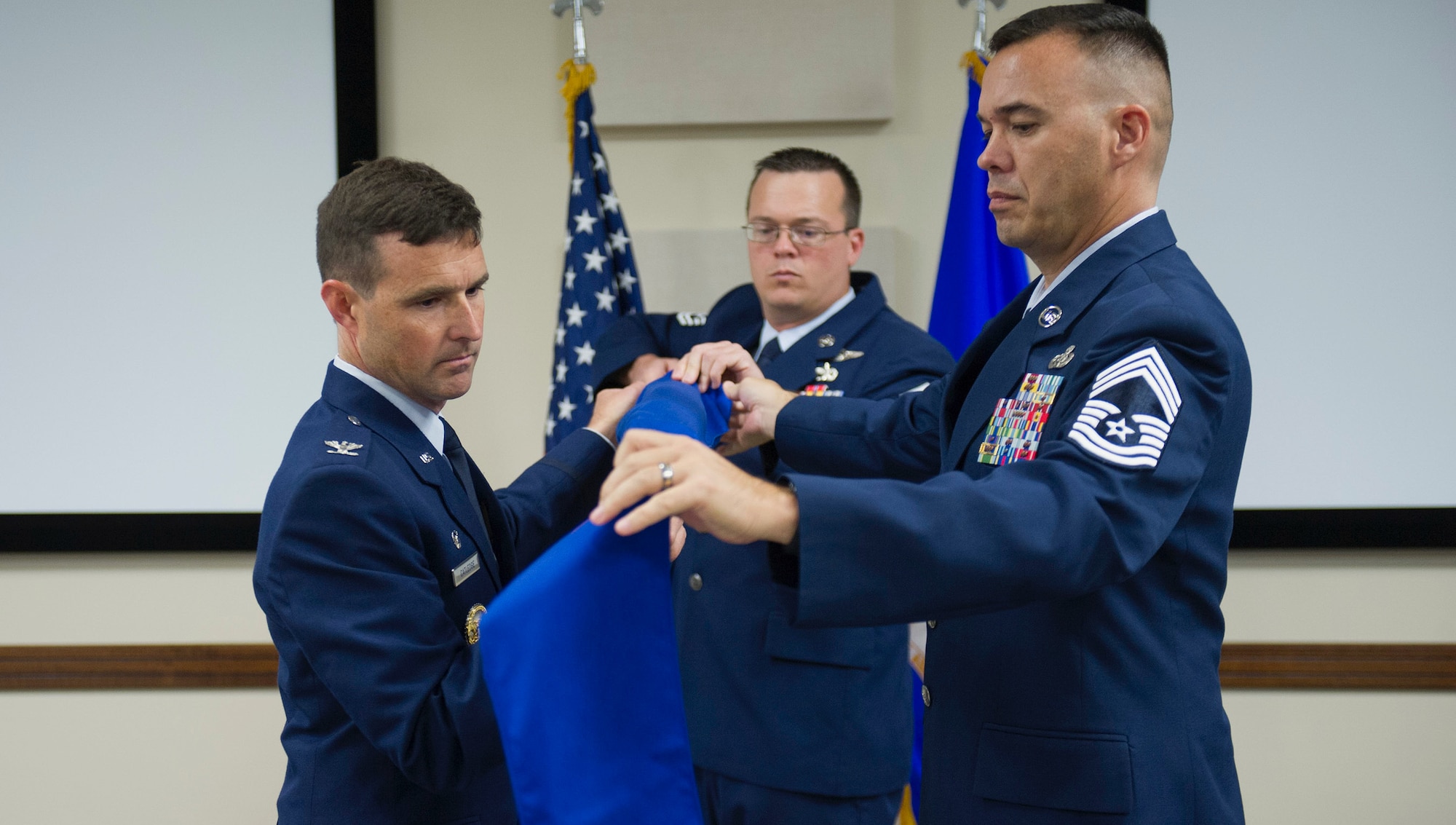 The 45th Space Wing Operations Group commander, Colonel Burton Catledge, assisted by Chief Master Sergeant Alec Hall, retires the Range Management Squadron flag at the inactivation ceremony on Friday, 6 October, 2017.