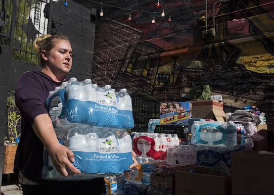 Shannon Janelle, mother of two and wife of Staff Sgt. Jeffrey Janelle, an instructor assigned to the Nellis First Term Airman Center, carries water to a donation site in downtown Las Vegas, Oct. 5, 2017. Shannon teamed with more than 30 spouses, friends and families to collect donated items for those at Sunrise Hospital, the University Medical Center of Southern Nevada, the Las Vegas Convention Center and the Las Vegas fire and police departments. (U.S. Air Force photo by Senior Airman Kevin Tanenbaum/Released)
