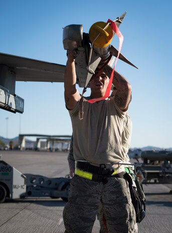 Airmen from the 57th Maintenance Group arm an F-16 Fighting Falcon during a load crew competition at Nellis Air Force Base, Nev., Oct. 6, 2017. Small teams worked together to load multiple large munitions on the aircraft. (U.S. Air Force photo by Airman 1st Class Andrew D. Sarver/Released)