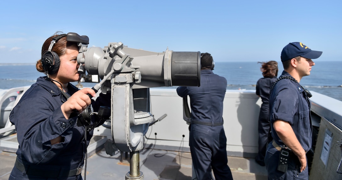 Sailor looks through binoculars.