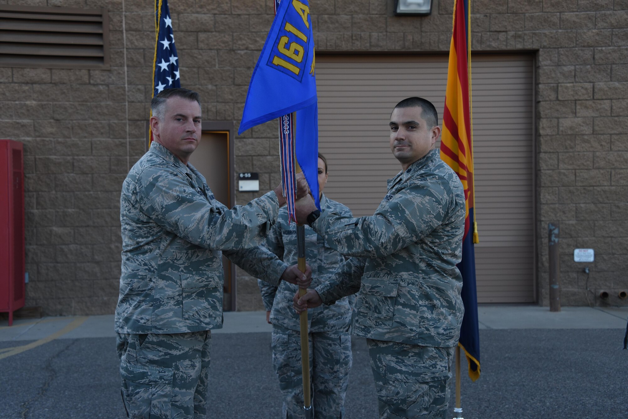 Col. David Ciesielski, 161st Air Refueling Wing Mission Support Group commander, passes the guidon to Lt. Col. Vince Navarro as he assumes command of the 161st Security Force Squadron, Oct. 7. (U.S. Air National Guard photo by 2nd Lt. Tinashe Machona).