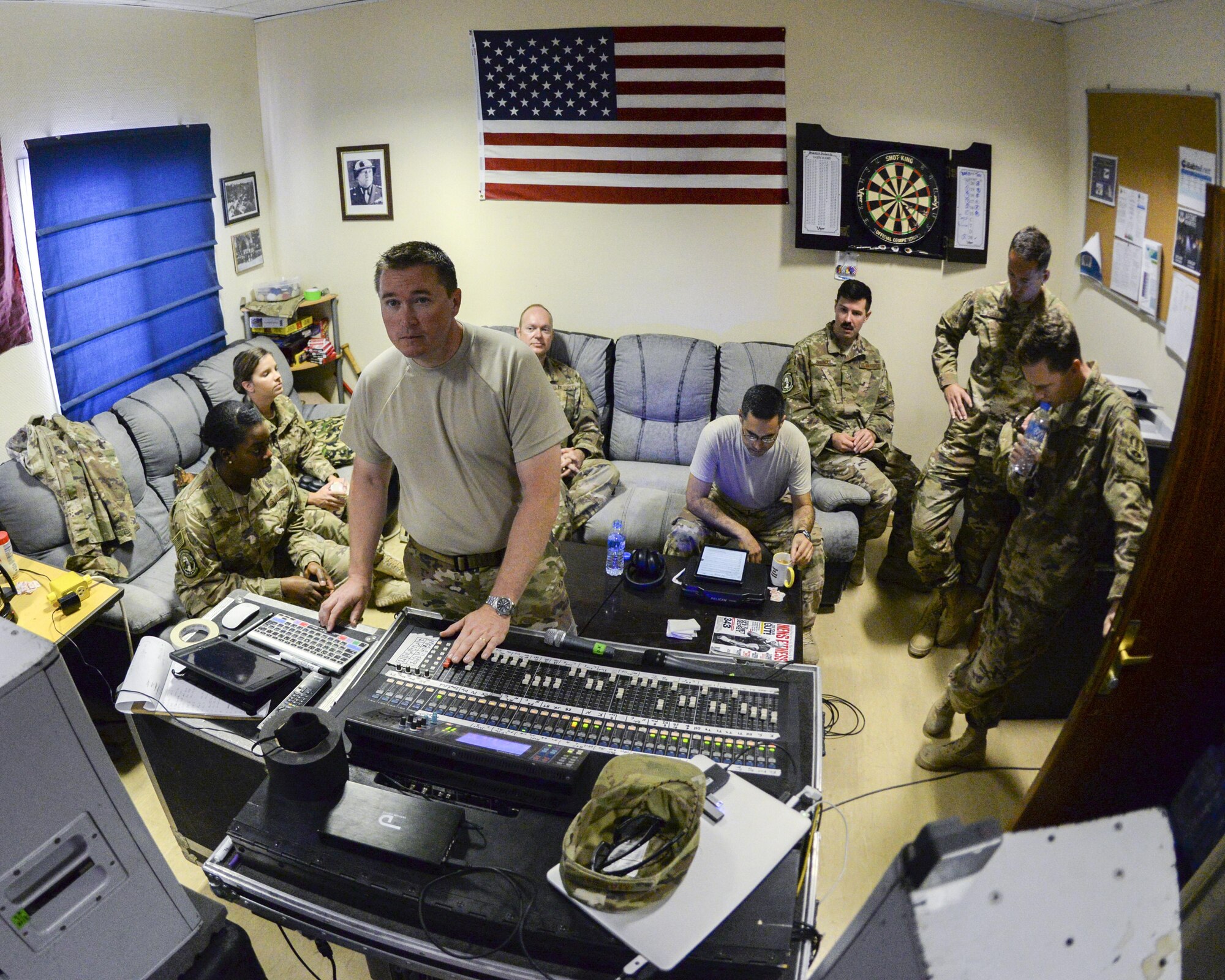 Members of the U.S. Air Force Central Command Band, Touch-n-Go, gathered behind U.S. Air Force Tech. Sgt. John Marsh, foreground, audio engineer, as they listen to a recording they recently cut of the Air Force Song at Al Udeid, Air Force Base, Qatar, Sept. 21, 2017.