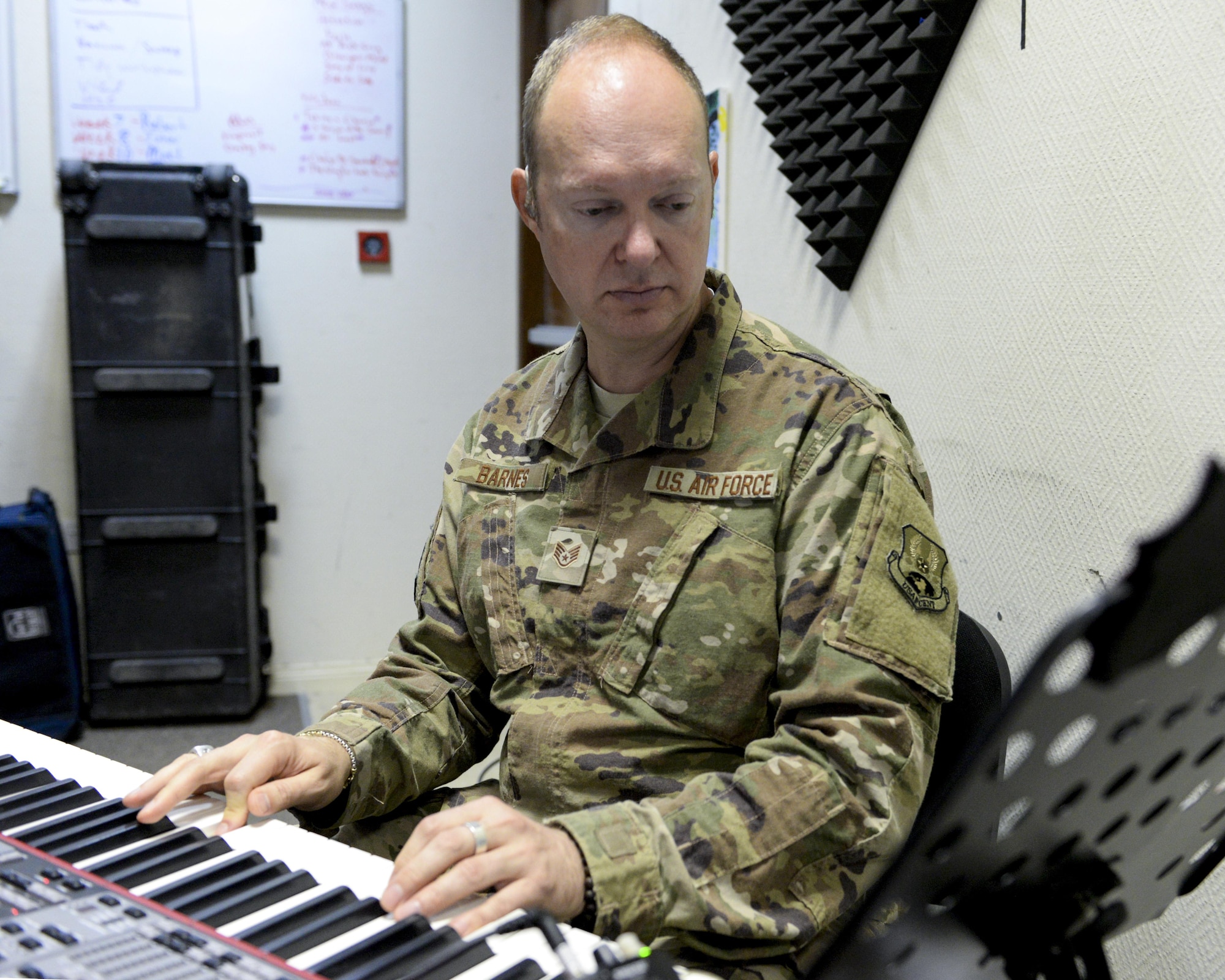 U.S. Air Force Staff Sgt. Robert Barnes, keyboardist assigned to the Air Force Central Command Band, Touch-n-Go, plays keyboard during a recording session as the band recorded their punk rock rendition of the Air Force Song at Al Udeid, Air Force Base, Qatar, Sept. 21, 2017.