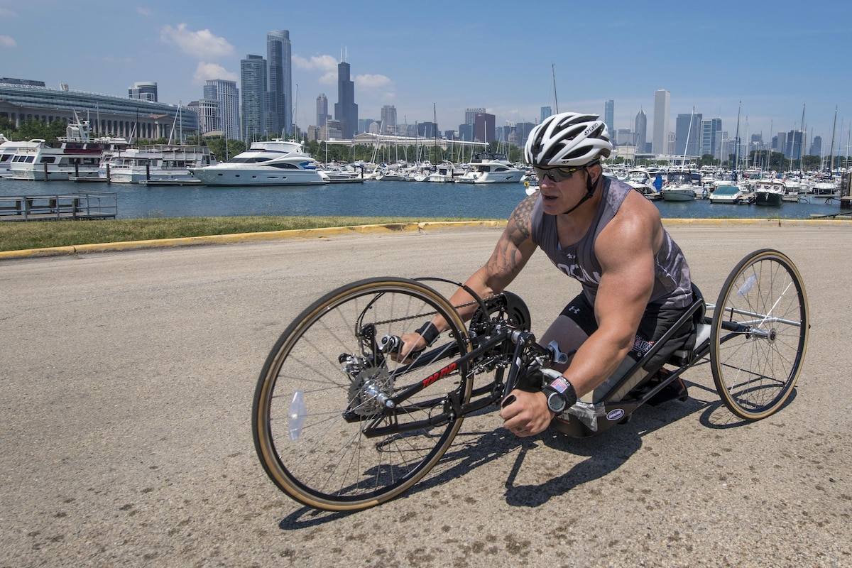 A cyclist competes in an event with the Chicago skyline behind him.