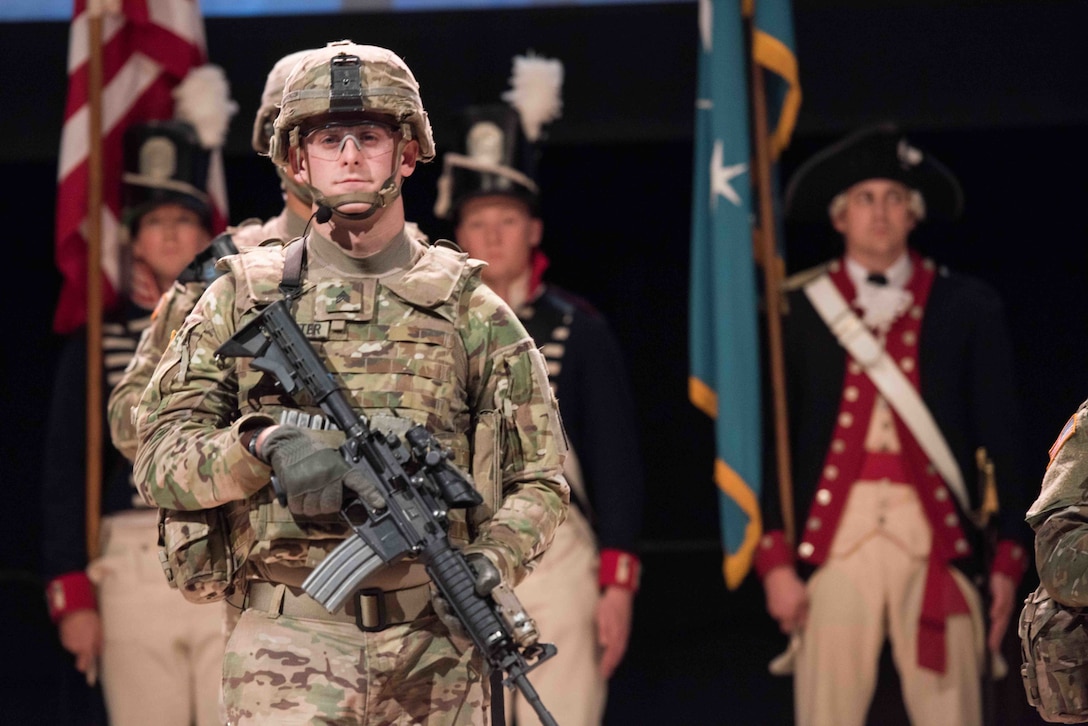 Soldier in battle gear participates in ceremony to open conference.