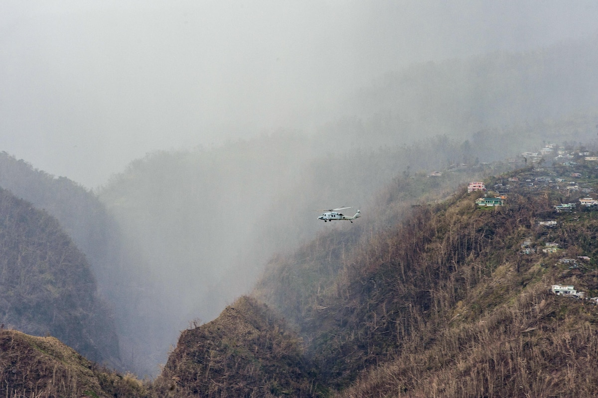 A helicopter evacuates residents from a mountain community.