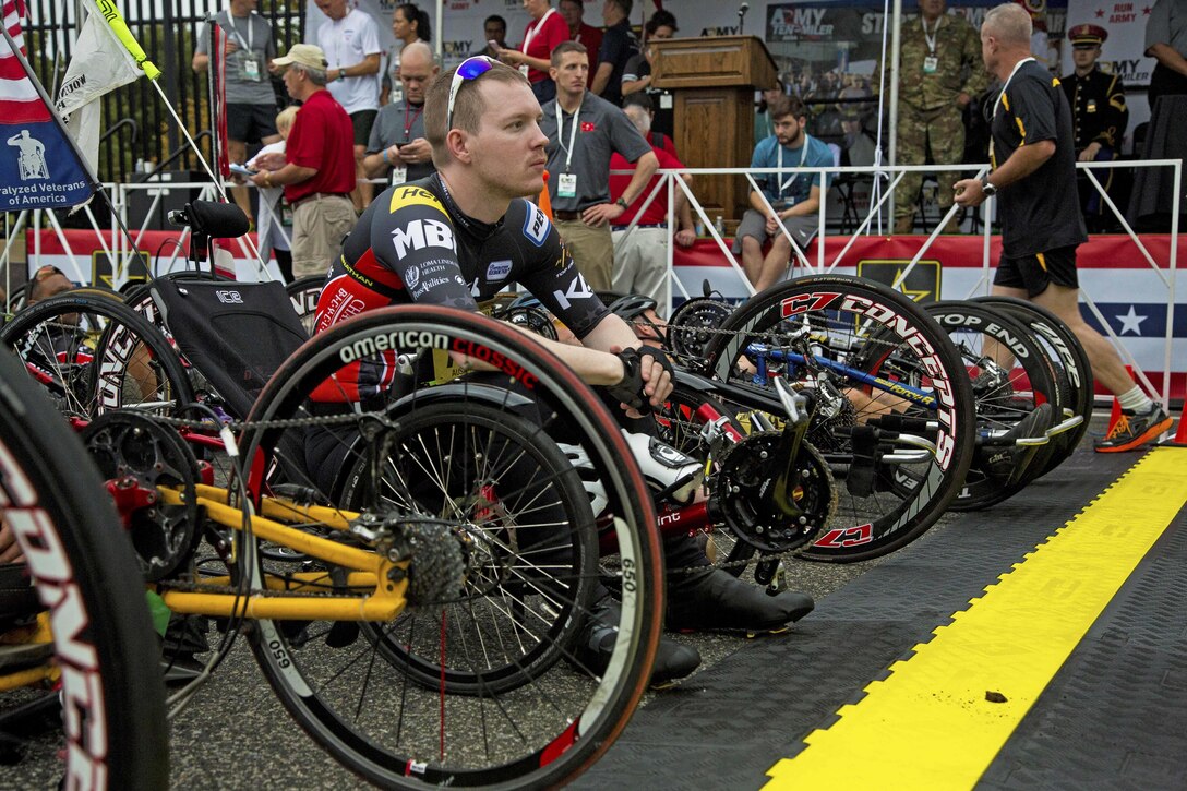 A wounded warrior on a modified bicycle awaits the start of a race.