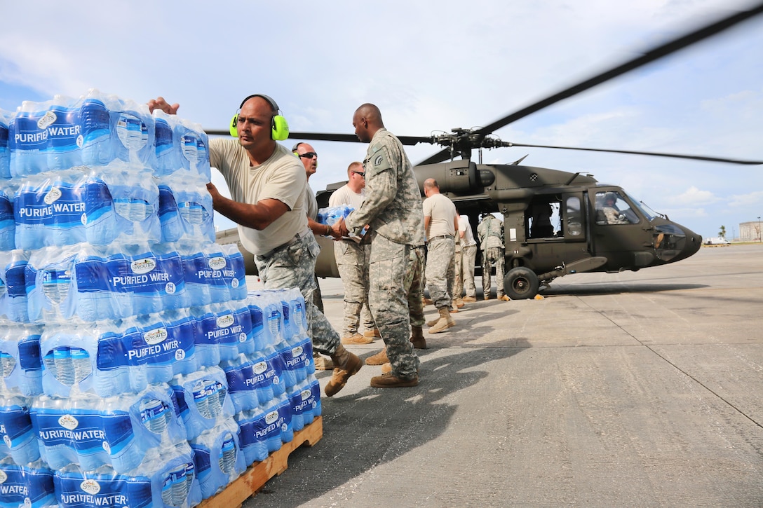 Soldiers load bottled water onto a UH-60 Black Hawk helicopter in San Juan.