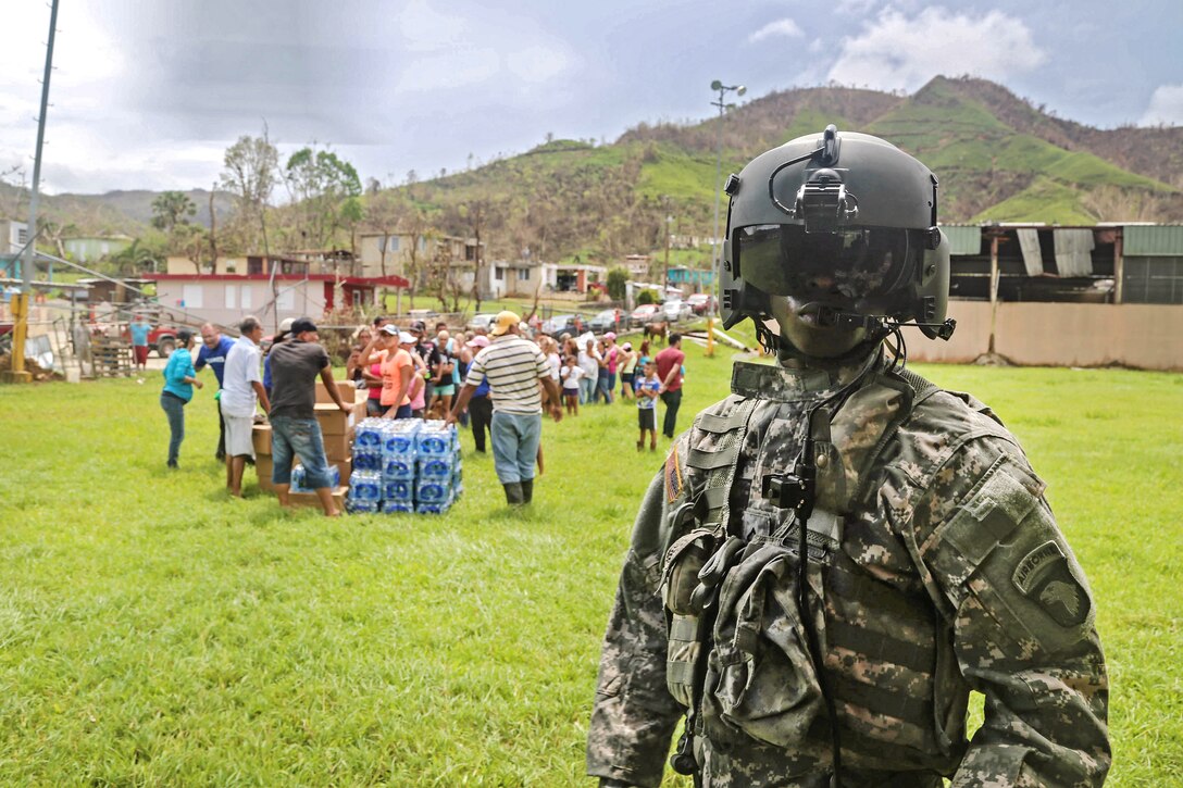 Soldiers finish unloading food and water from a HH-60 Black Hawk helicopter for local residents near San Juan.