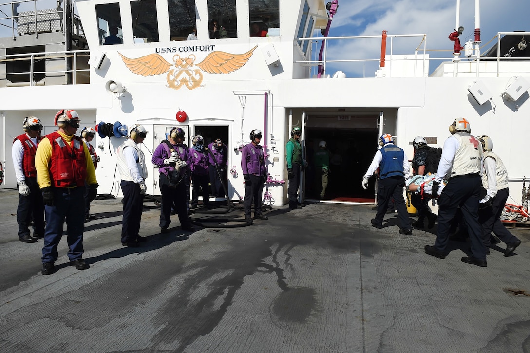 Sailors transport a patient from Menonita Hospital in Caguas, Puerto Rico, aboard the Military Sea Military Sealift Command hospital ship USNS Comfort.