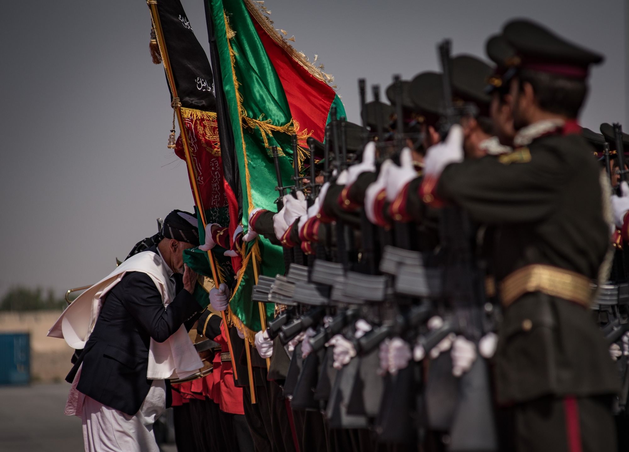 Afghanistan President Ashraf Ghani, left, ceremonially touches the Afghan national flag to his face Oct. 7, 2017, at Kandahar Airfield, Afghanistan. Ghani attended an inaugural ribbon cutting, commemorating the arrival of the UH-60 helicopter to the Afghan Air Force fleet. (U.S. Air Force photo by Staff Sgt. Alexander W. Riedel)