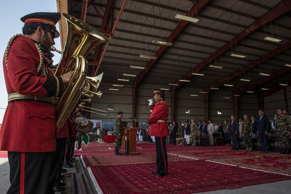 Afghan senior government and international military officials stand while the Afghan National Security and Defense Forces band plays during the beginning of the official arrival ceremony for the first UH-60 Black Hawk helicopters to the country, Oct. 7, 2017, at Kandahar Airfield, Afghanistan. Leaders signed an official transfer of ownership and performed a ceremonial ribbon cutting celebrating the newest addition to Afghanistan’s young air force fleet. (U.S. Air Force photo by Staff Sgt. Alexander W. Riedel)