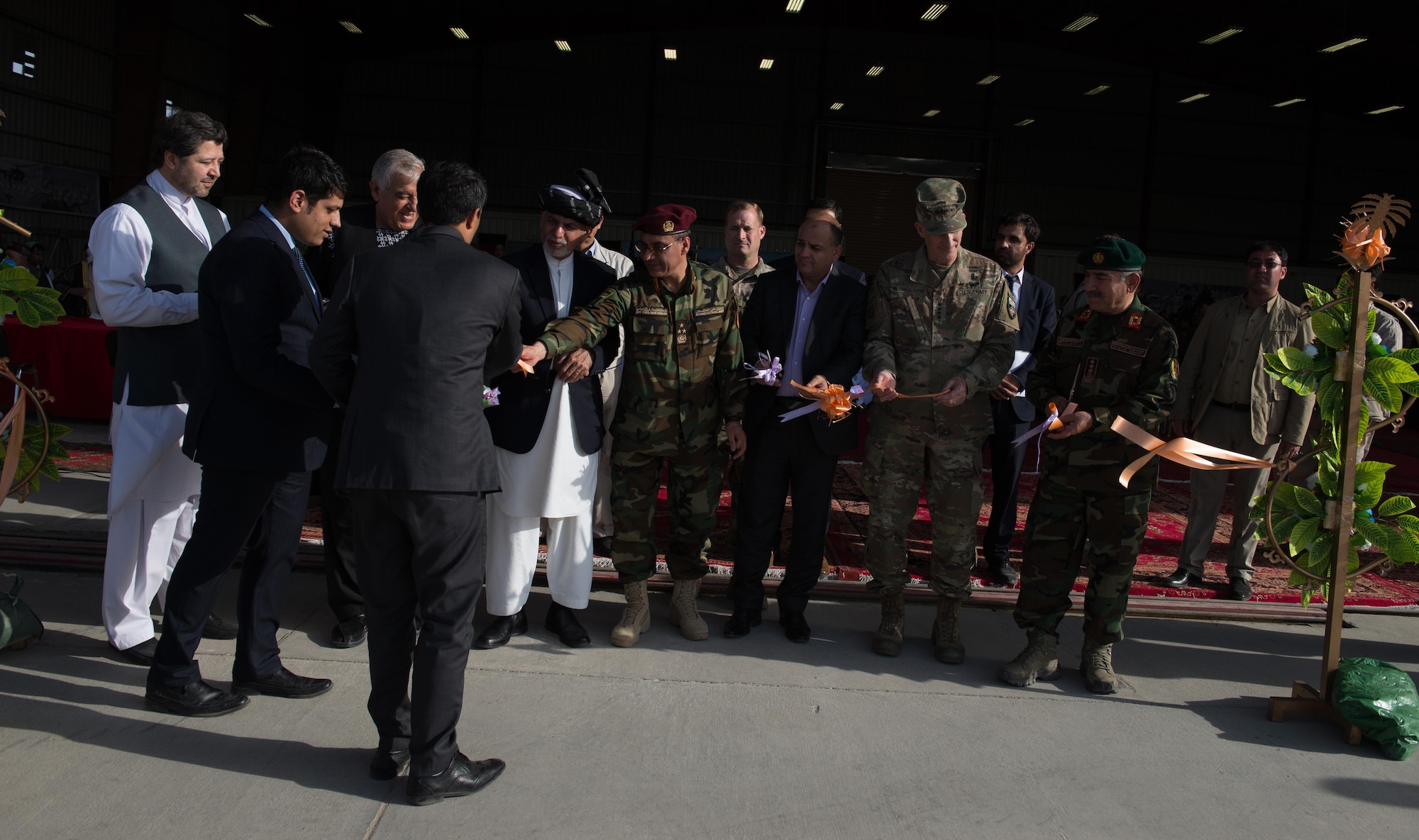 Senior Afghan government officials and coalition defense leaders share in a ribbon cutting symbolizing the transfer of ownership of the first UH-60 Black Hawk helicopter to the Afghan Air Force Oct. 7, 2017, at Kandahar Airfield, Afghanistan. The UH-60 has been selected to enhance the AAF helicopter fleet and augment the capabilities currently provided by the Mi-17 legacy platform. (U.S. Air Force photo by Staff Sgt. Alexander W. Riedel)