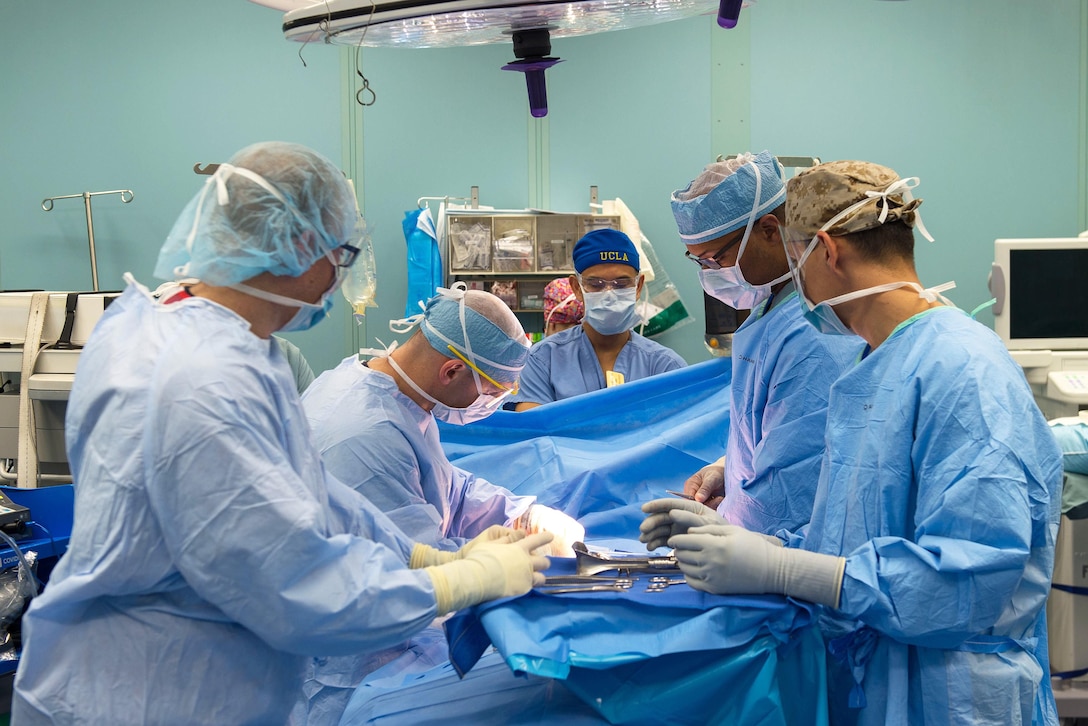 Navy medical personnel perform a surgical operation in an operating room aboard the hospital ship USNS Comfort.