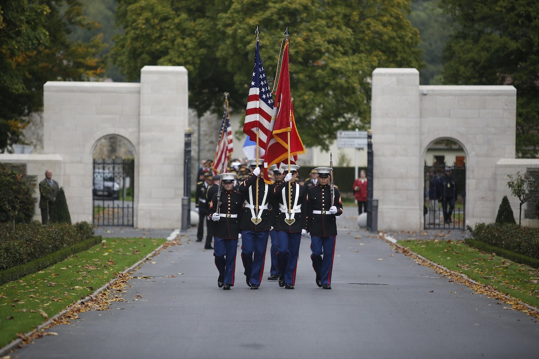 Marine Color Guard from Marine Corps Forces Europe and Africa march through the gate of the Aisne-Marne American Cemetery and Memorial during a wreath laying ceremony conducted by the Ancient and Honorable Artillery Company of Massachusetts in Belleau, France, Oct. 1, 2017. U.S. Marine Corps Forces Europe and Africa routinely conducts theater engagement and outreach throughout its Area of Responsibility, and provided a Color Guard and Rifle Detail for the event that took place at the foot of the hill where the Battle of Belleau Wood was fought. (U.S. Marine Corps photo by 2ndLt. Brett Lazaroff/Released)