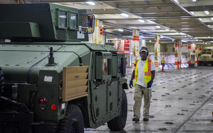 A civilian contractor lines up a military vehicle during an on-load at Joint Base Charleston-Weapons Station, S.C., Sept. 27, 2017.