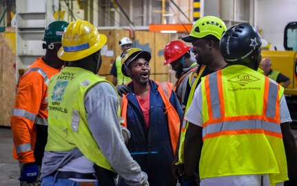 Civilian contractors talk in a huddle before loading military vehicles at Joint Base Charleston-Weapons Station, S.C., Sept. 27, 2017.