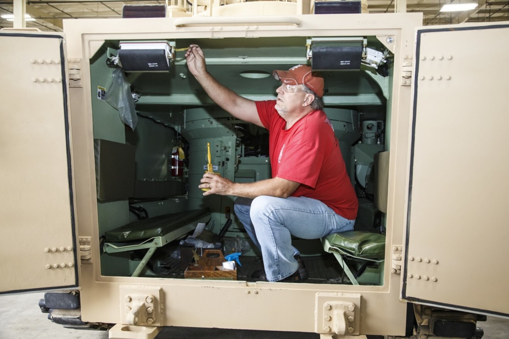 Ronald Wilkinson with DLA Distribution Anniston, Ala., applies glue to components in a M113A3/BMP-2 Opposing Forces Surrogate Vehicle prior to shipping from Anniston Army Depot. The installation recently completed overhaul of 14 of these training vehicles, which are designed to look like Russian combat vehicles.