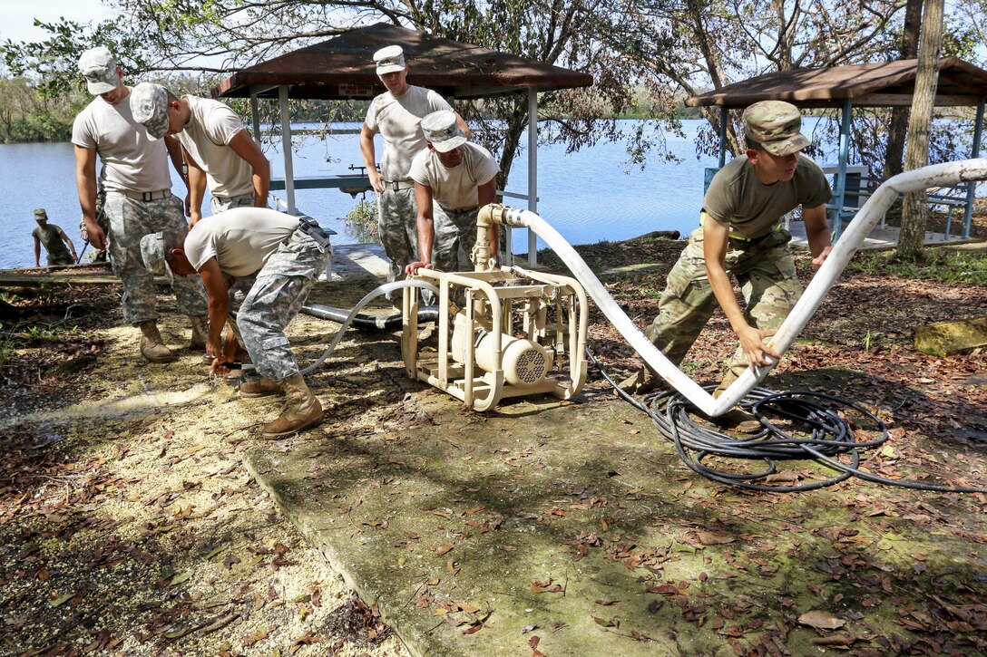 Soldiers use equipment to purify water from a lake.