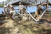 Soldiers use equipment to purify water from a lake.