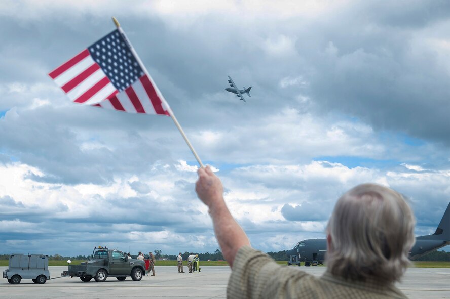 A spectator watches a flying HC-130J Combat King II during the 71st Rescue Squadron’s (RQS) redeployment, Oct. 6, 2017, at Moody Air Force Base, Ga. Airmen from the 71st RQS supported deployed operations by providing expeditionary personnel with on-call recovery forces should they need to be rescued. (U.S. Air Force photo by Senior Airman Greg Nash)