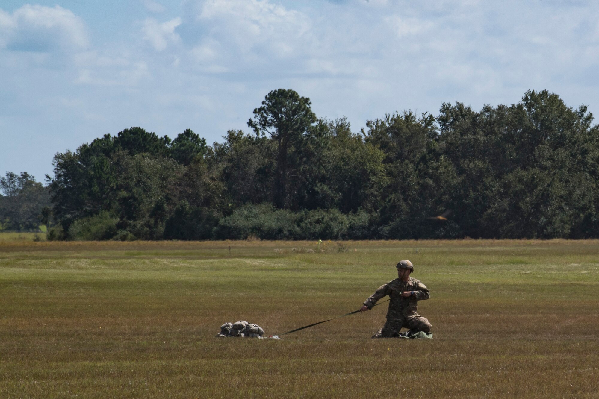 Tech. Sgt. Vanloon, 820th Combat Operations Squadron NCO in charge of individual combat equipment, gathers a MC-6 parachute after a static-line jump, Oct. 3, 2017, at the Lee Fulp drop zone in Tifton, Ga. During a static-line jump, the jumper is attached to the aircraft via the ‘static-line’, which automatically deploys the jumpers’ parachute after they’ve exited the aircraft. (U.S. Air Force photo by Airman 1st Class Daniel Snider)