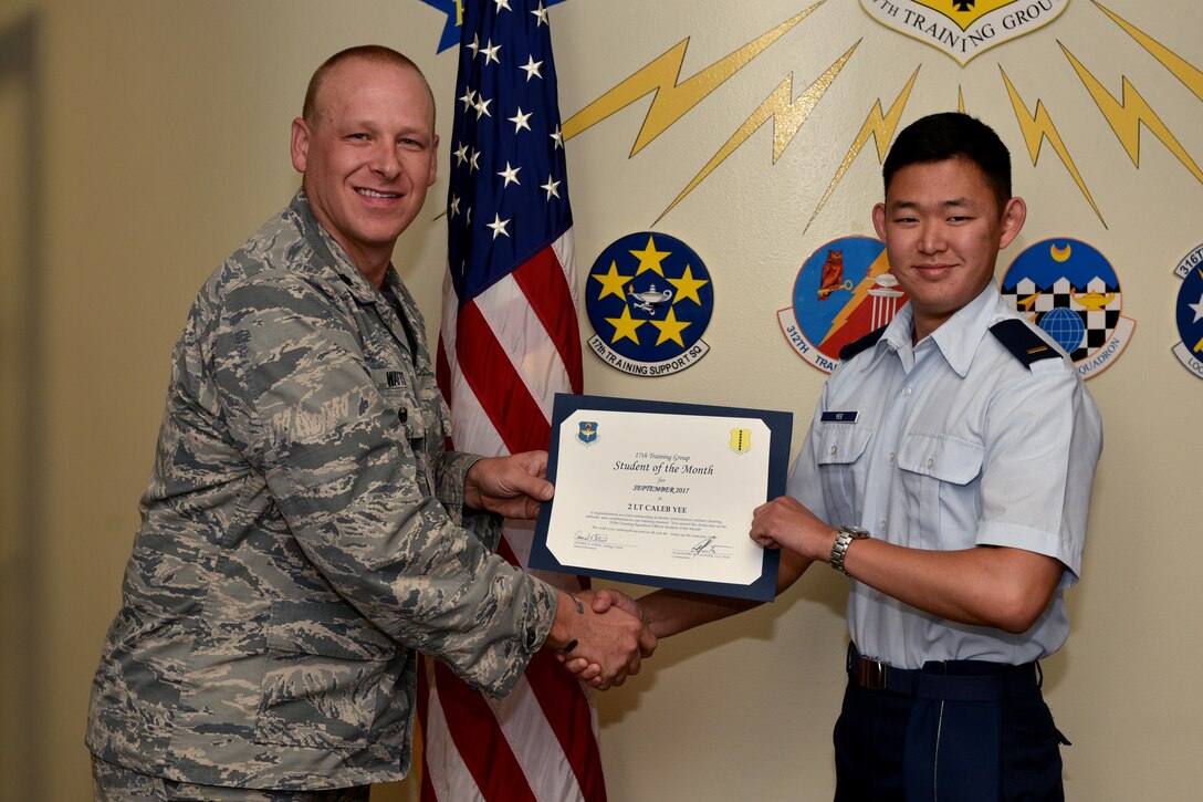 U.S. Air Force Lt. Col. Steven Watts, 17th Training Group deputy commander, presents the 315th Training Squadron Officer Student of the Month award for Sept. 2017 to 2nd Lt. Caleb Yee, 315th Training Squadron trainee, in the Brandenburg Hall on Goodfellow Air Force Base, Texas, Oct. 5, 2017. The 17th Training Wing's mission is to develop and inspire exceptional intelligence, surveillance and reconnaissance, and fire protection professionals for America and her allies. (U.S. Air Force photo by Airman 1st Class Randall Moose/released)