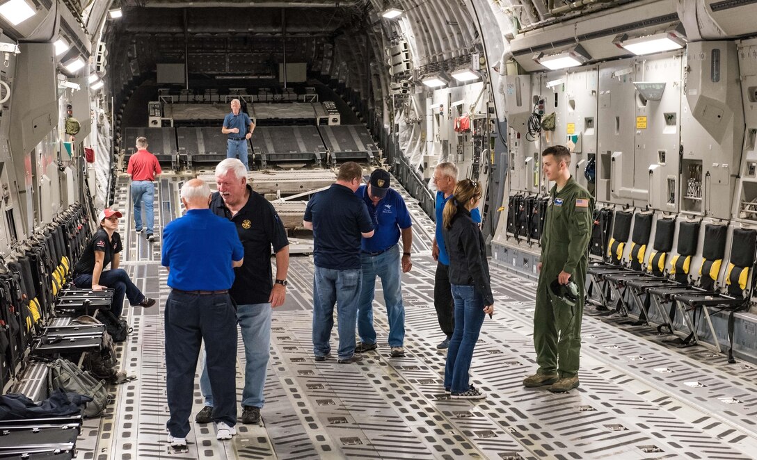 Senior Airman Andrew Gwinn, 3d Airlift Squadron loadmaster, answers questions from NASCAR team members about the C-17 Globemaster III and his duties Sept. 28, 2017, on Dover Air Force Base, Del. Gwinn was a member of a 3d AS aircrew that took more than 20 participants on a NASCAR orientation flight. (U.S. Air Force photo by Roland Balik)