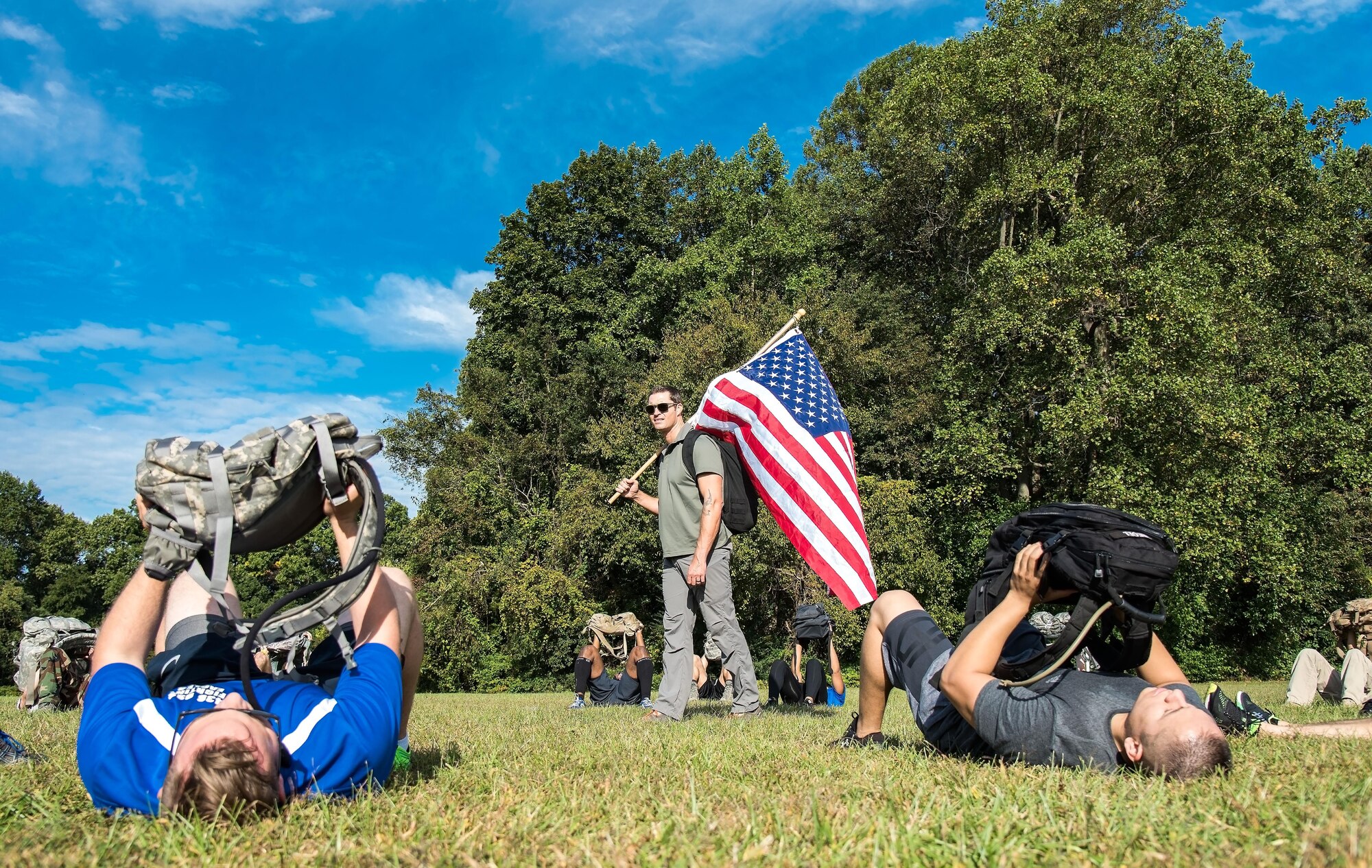 U.S. Army Master Sgt. Todd Fetzer, 1st Special Forces Command (Airborne), Ft. Bragg, N.C., watches GORUCK participants press their rucksack during warm-up exercises Oct. 6, 2017, at Brecknock Park in Camden, Del. Twenty-nine individuals completed the 2017 GORUCK Light Challenge. (U.S. Air Force photo by Roland Balik)